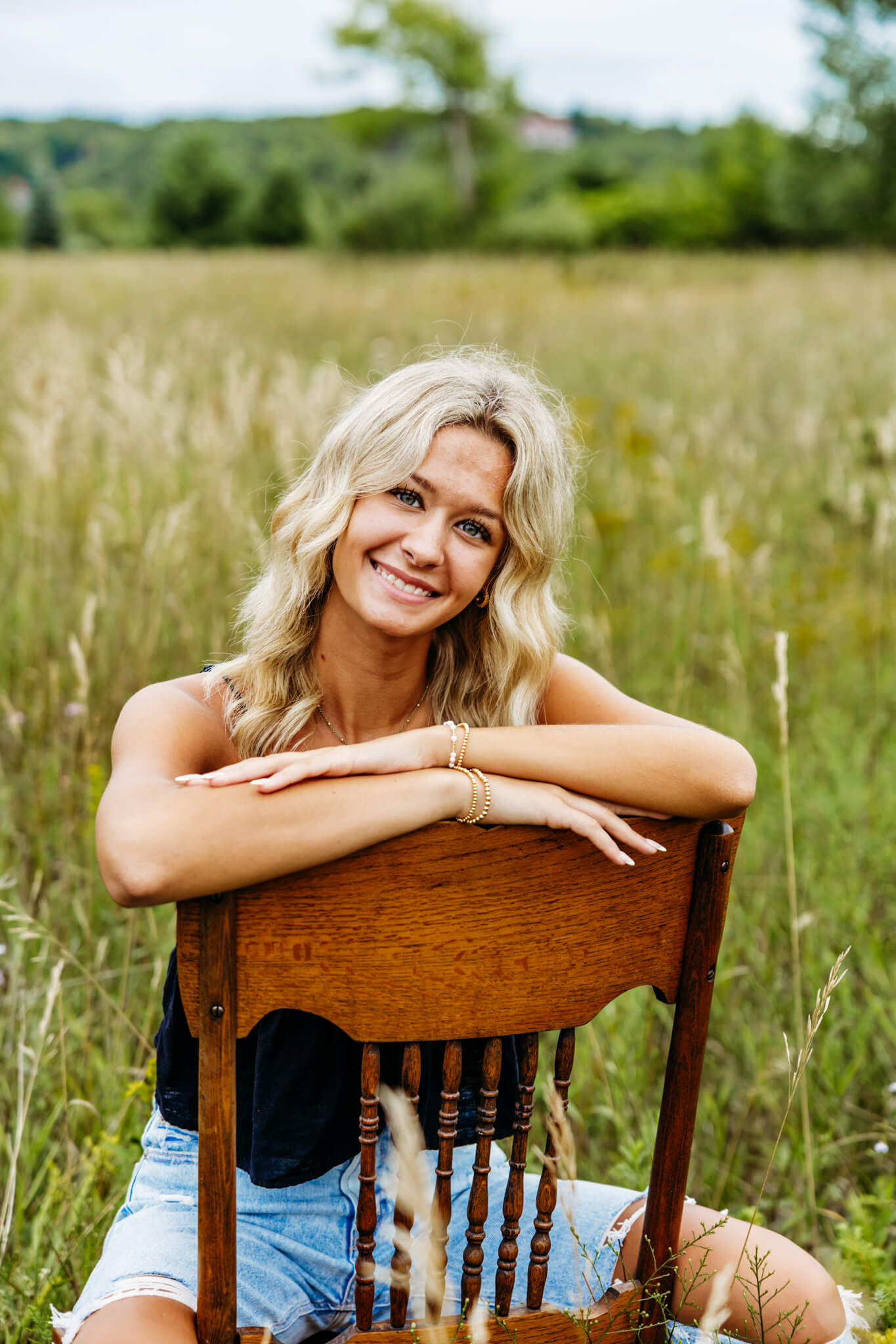 Young lady sitting on a chair in a field