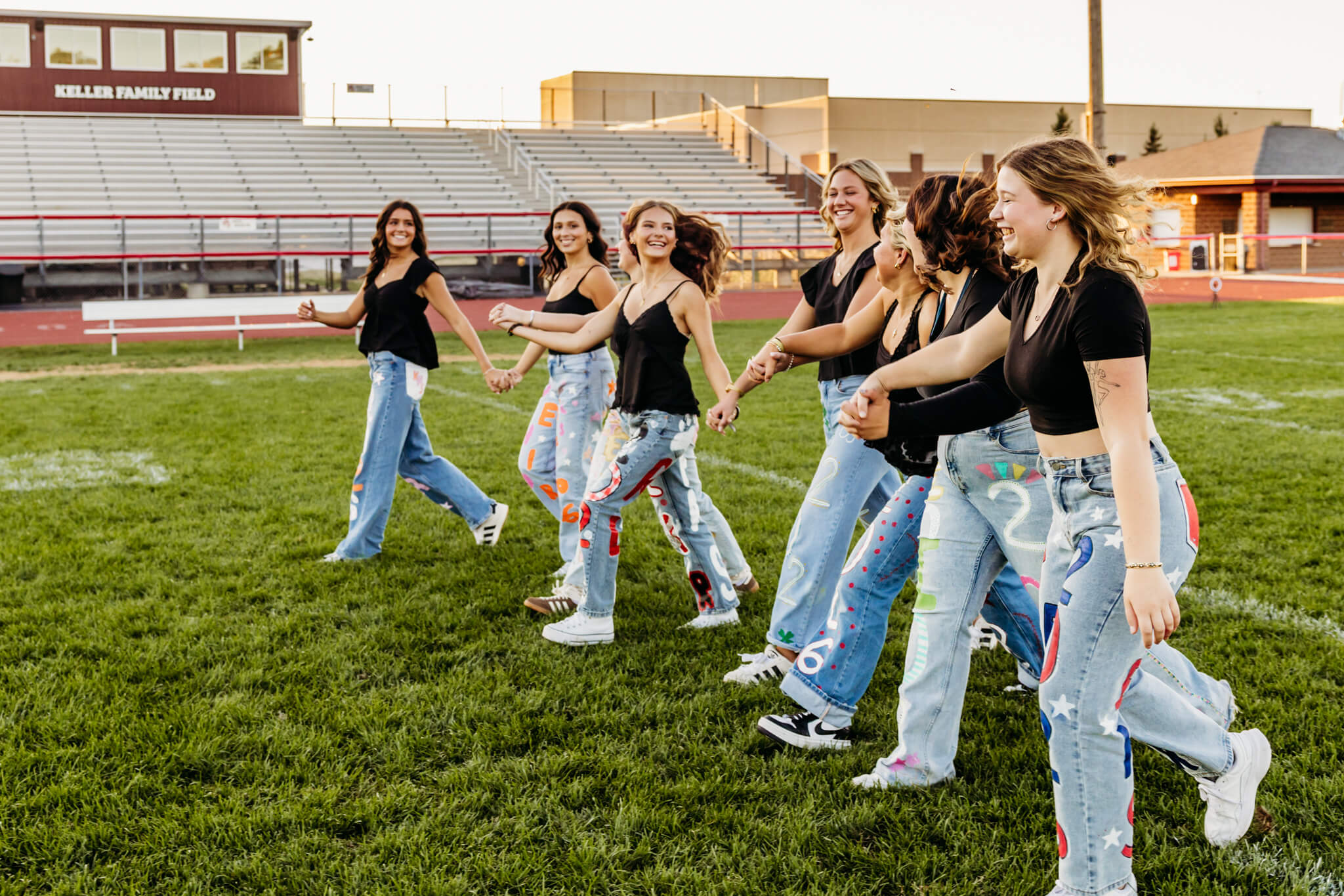 Eight high school ladies walking together on the football field in Green Bay.