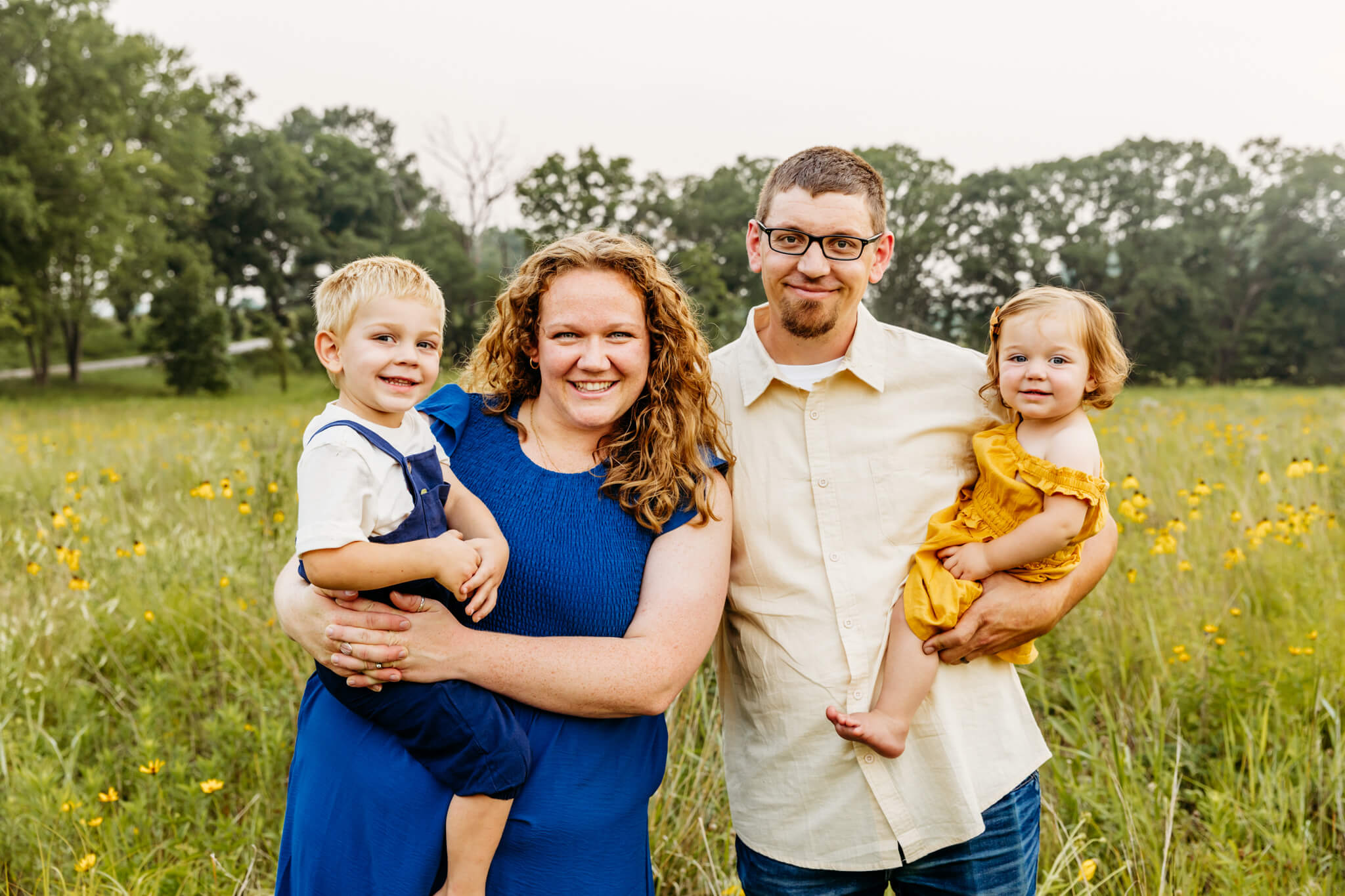 beautiful family of four snuggling and smiling for their family photo session in Oshkosh