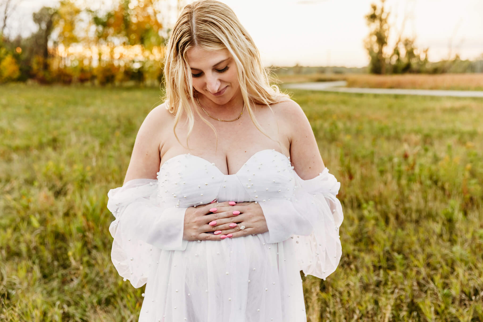 gorgeous mom to be looking down at her baby bump and enjoying her maternity session