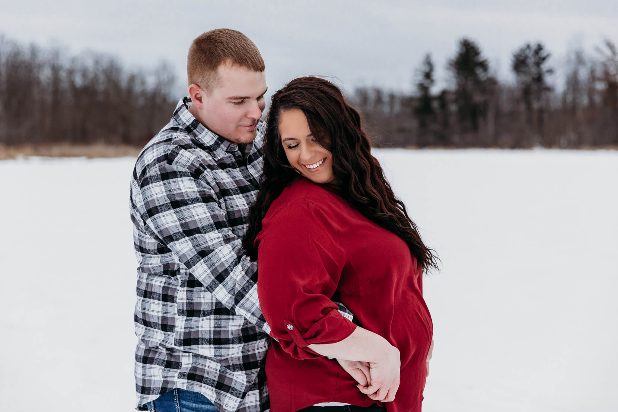 Couple snuggling during their winter engagement session in Appleton