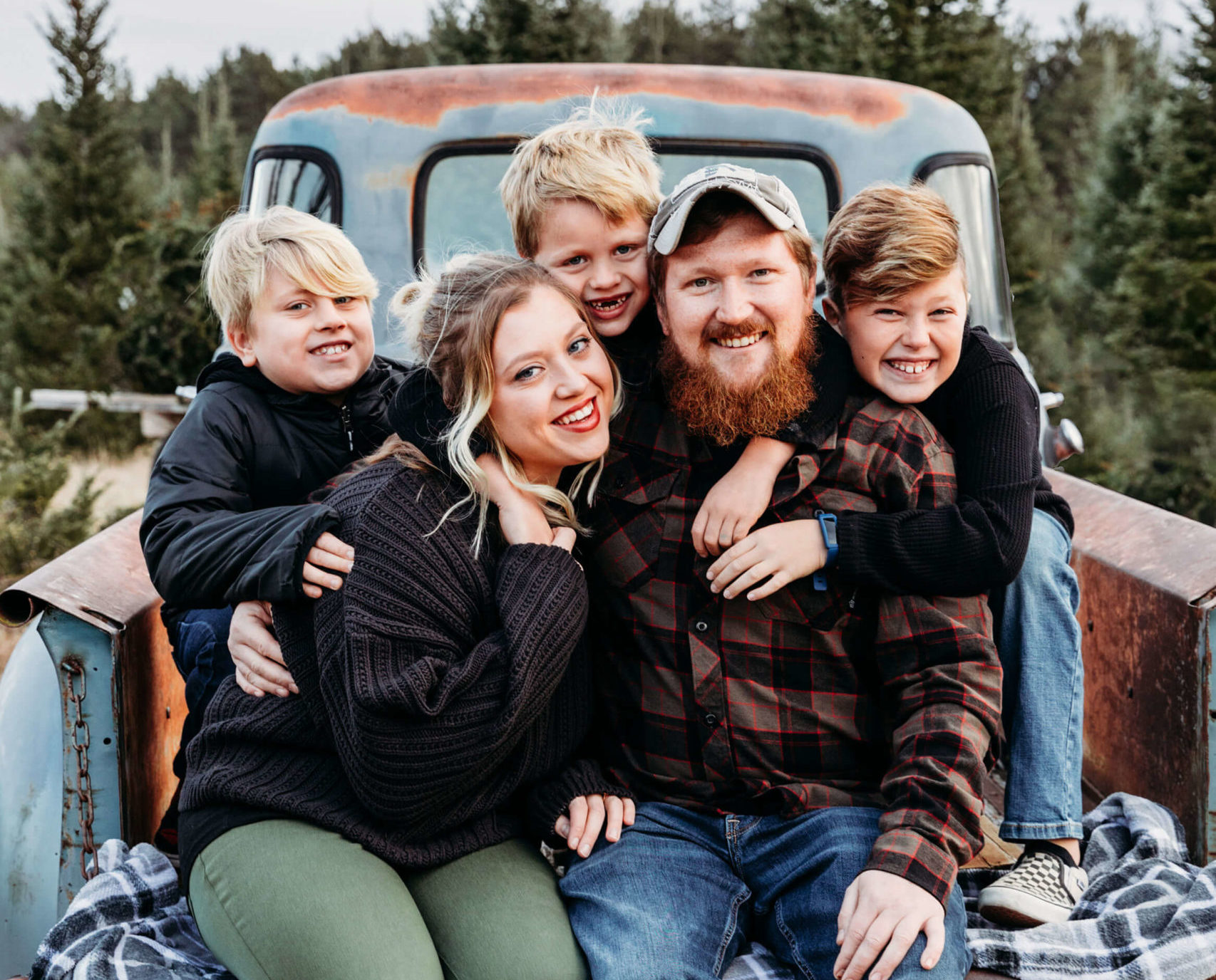 adorable family hugging each other in a vintage truck for blog post about spas in oshkosh