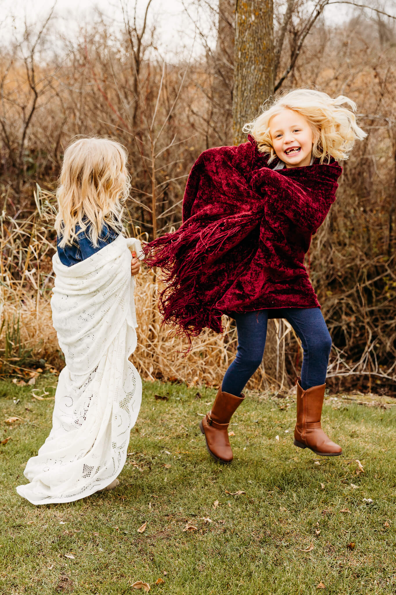 little girl jumping up in the area wrapped in a blanket