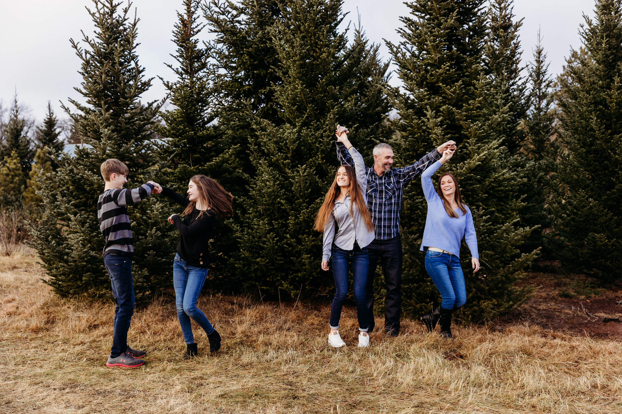 family of 5 dancing together in the trees by Ashley Kalbus