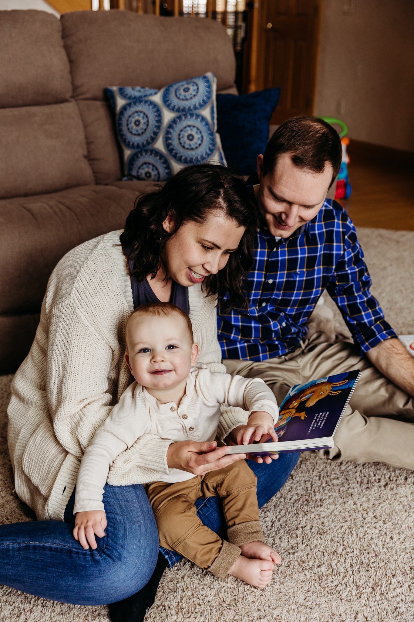 family of three reading on the ground in their home