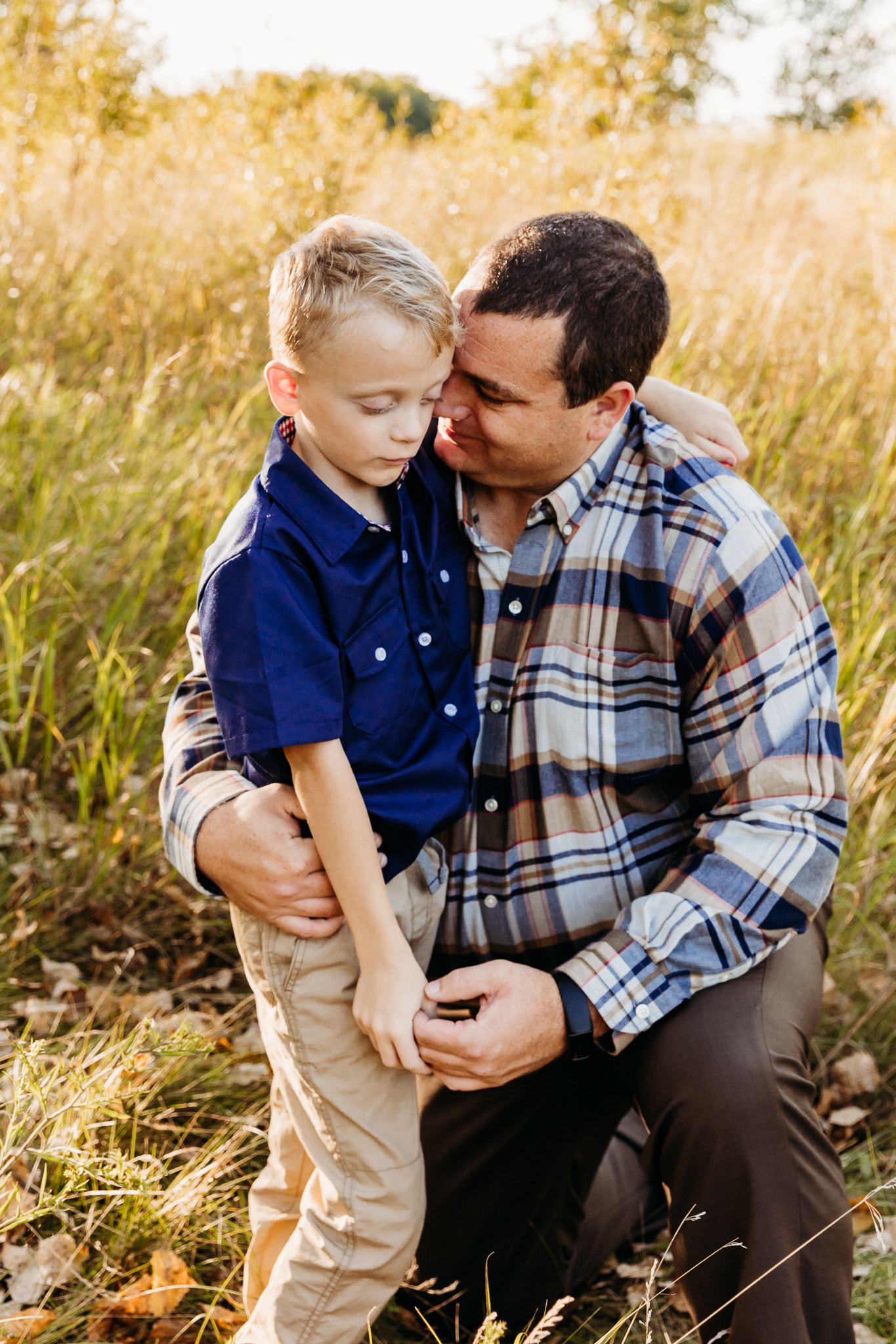 dad hugging his son in a field in Sturgeon Bay