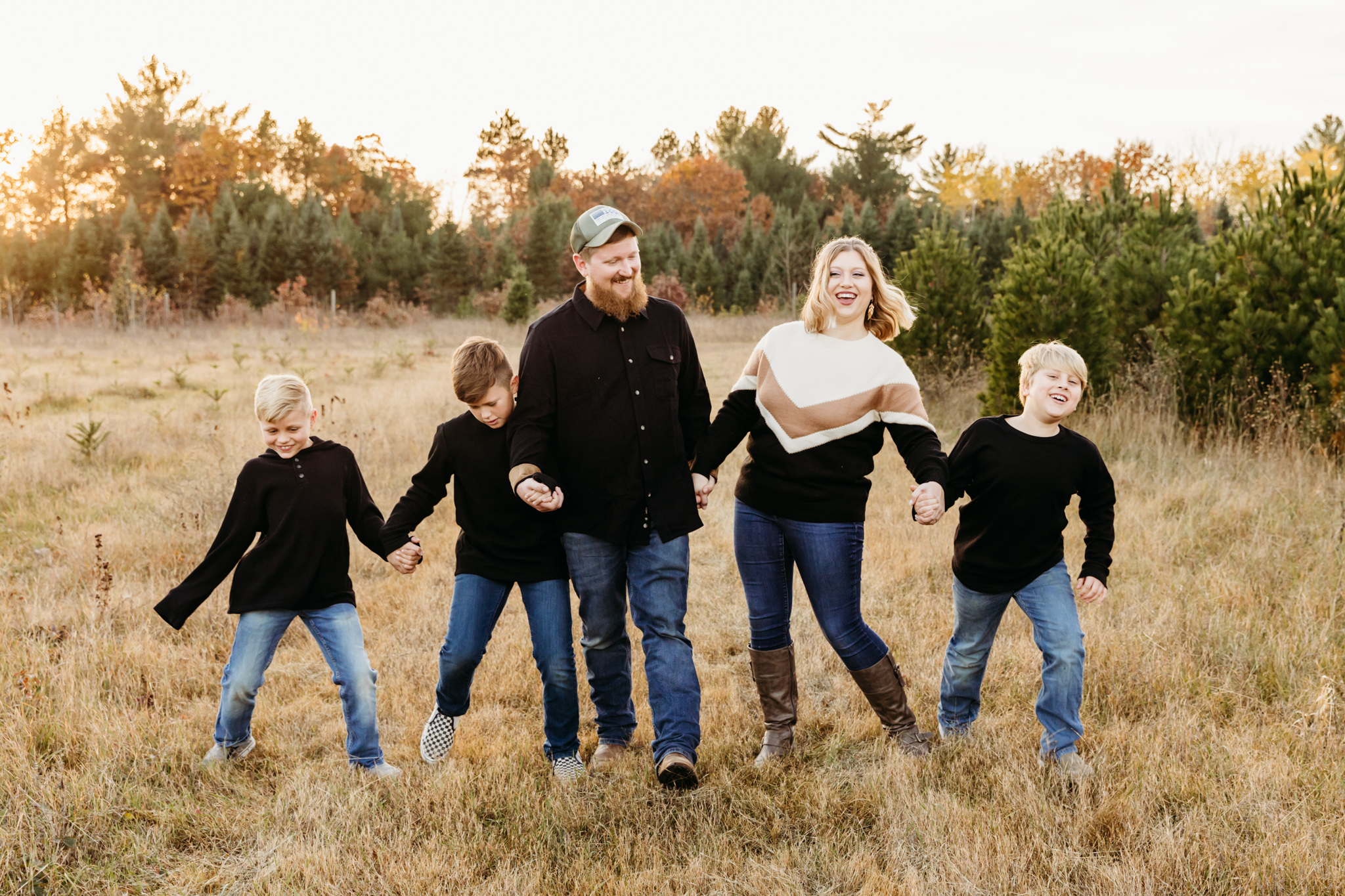 family of 5 playing in a field while wearing black