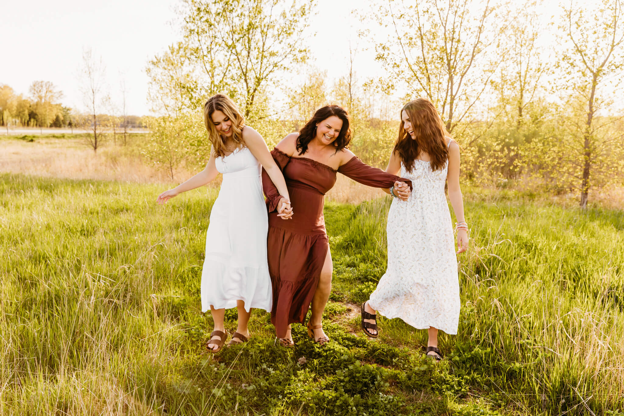 mom and her two teen daughters walking and laughing during their family photo session