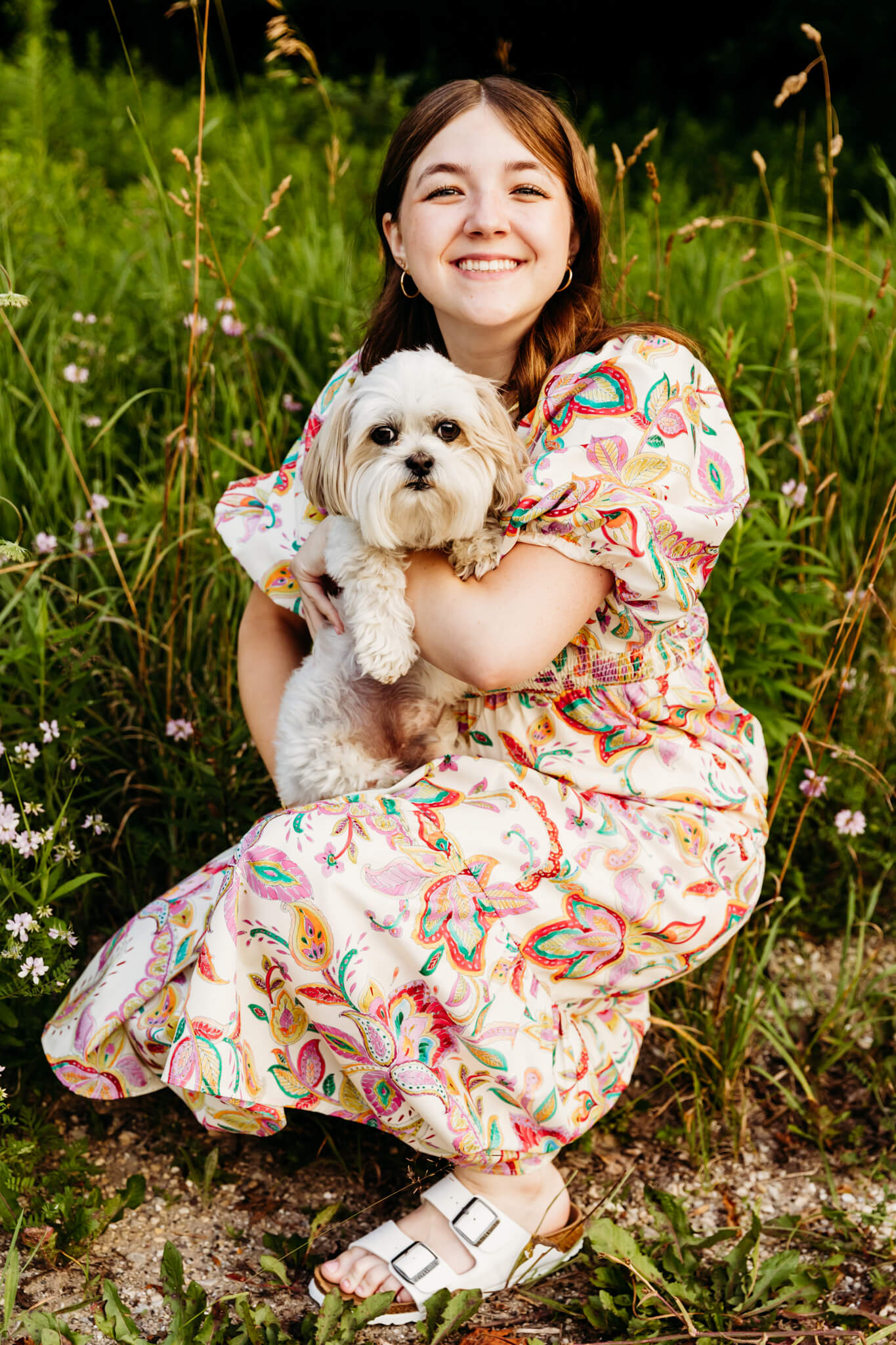 high school girl in a colorful dress holding her dog during her photo session