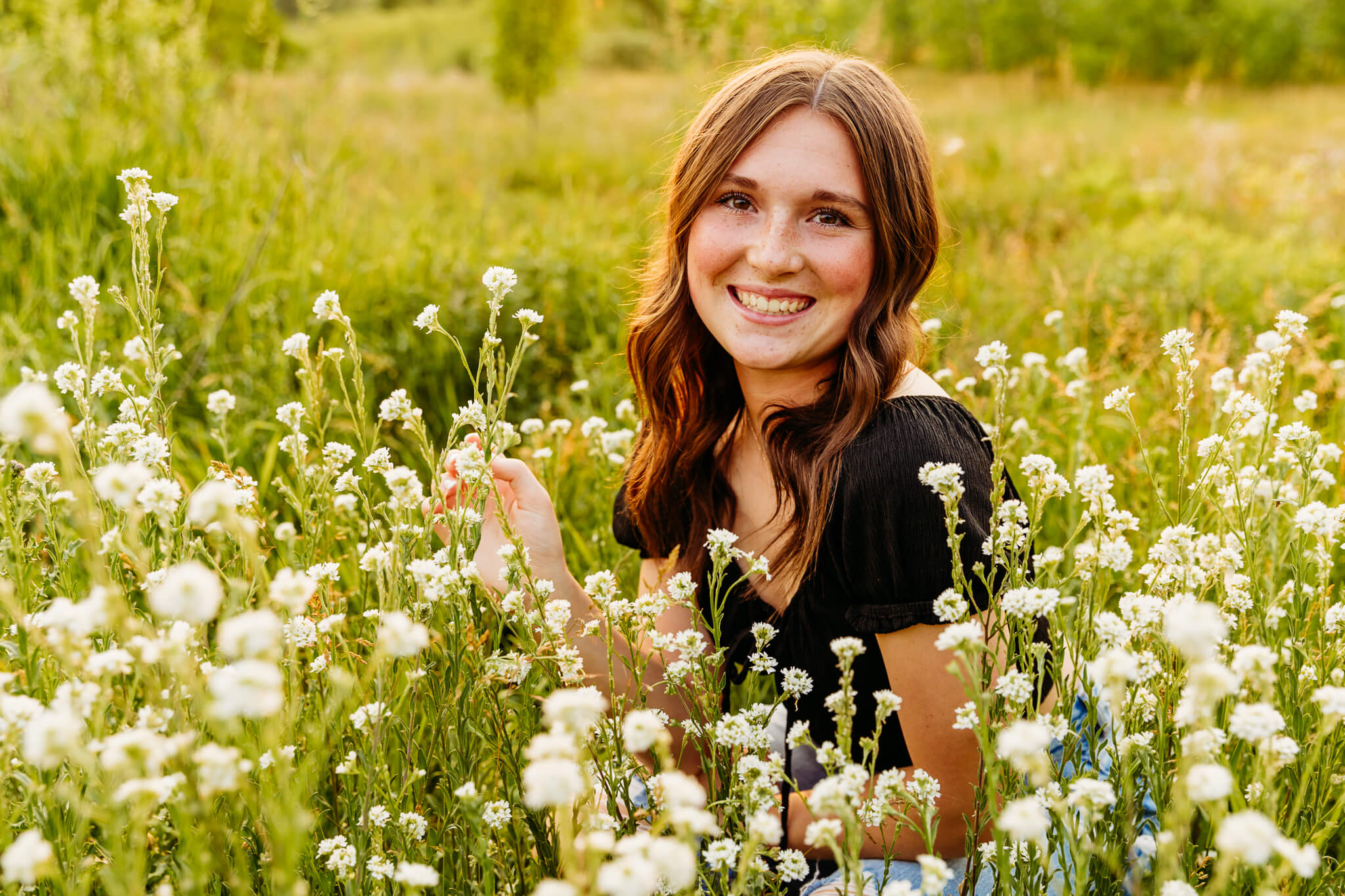 bay port high school senior girl sitting in a field of white flowers
