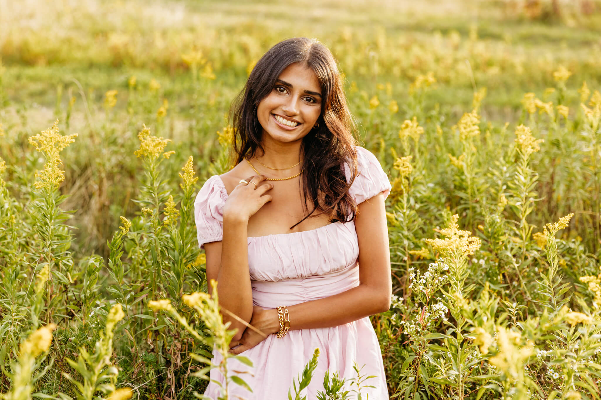 high school girl in a light pink dress sitting in goldenrod in a field near Green Bay