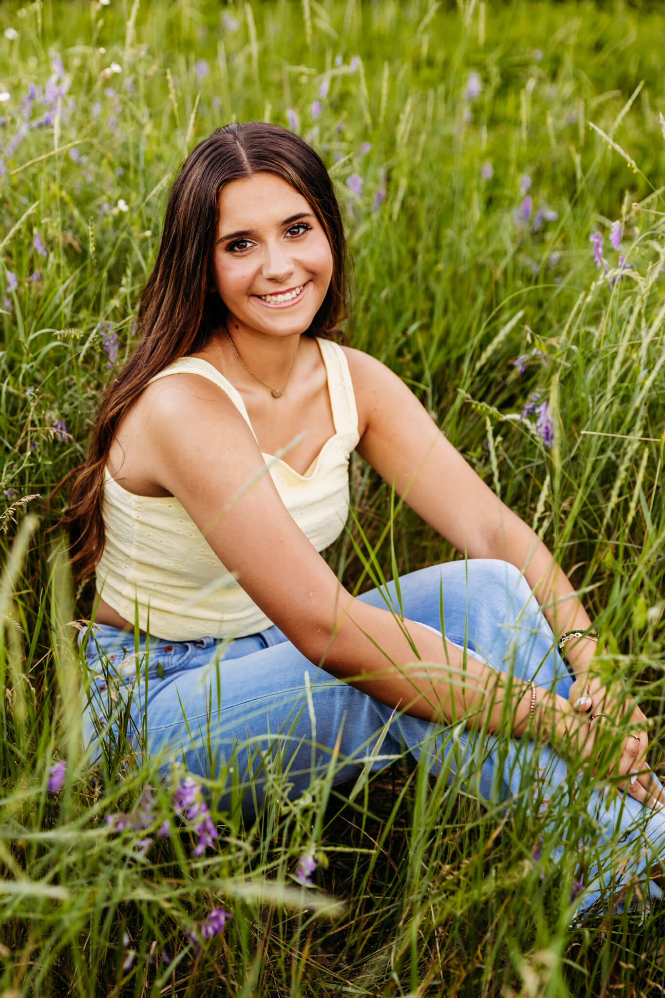 Kimberly High School senior sitting in a wildflower field during her senior session