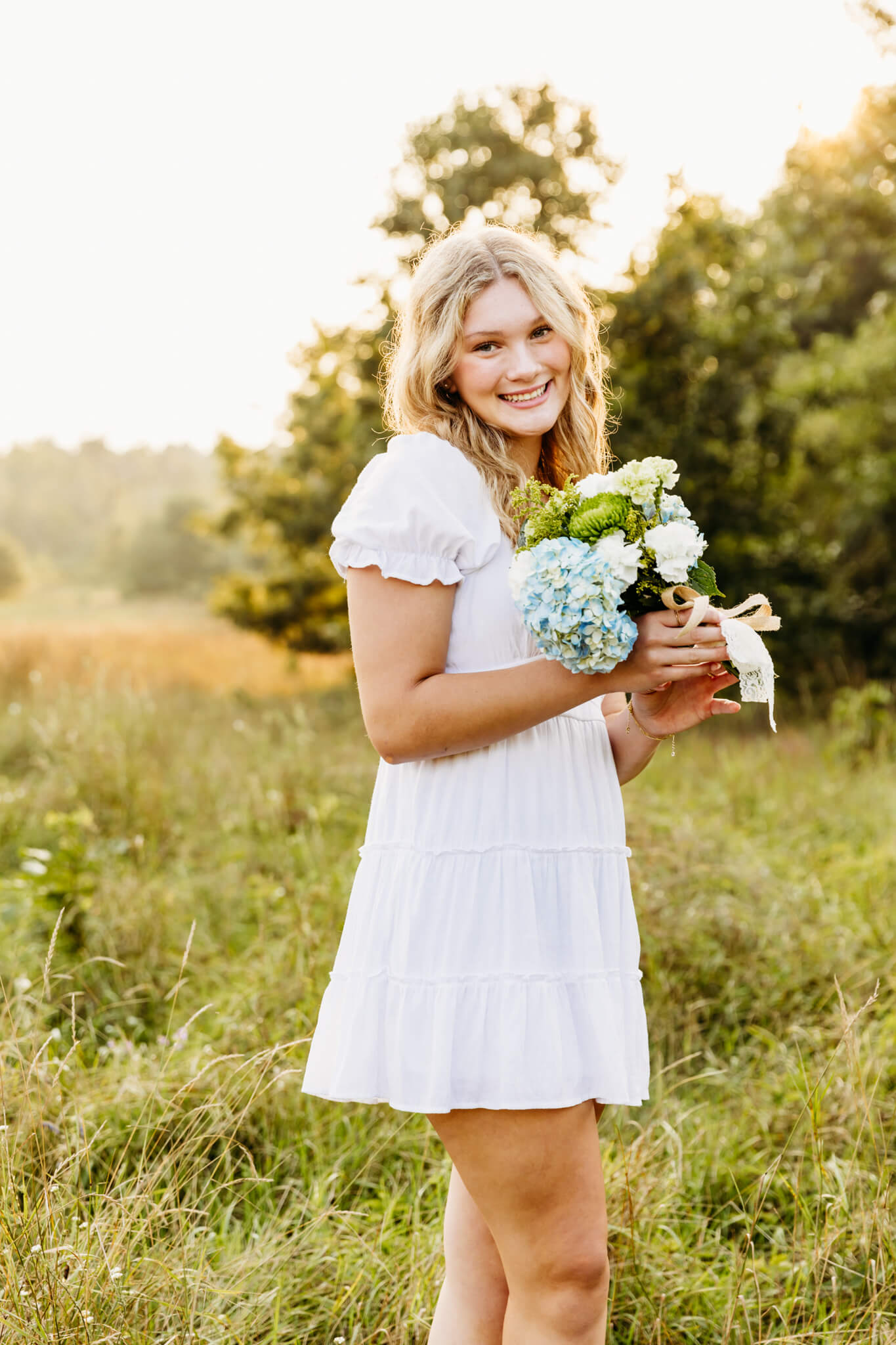 gorgeous high school student holding a bouquet of flowers from Holiday Florist in Winneconne for her senior photo session