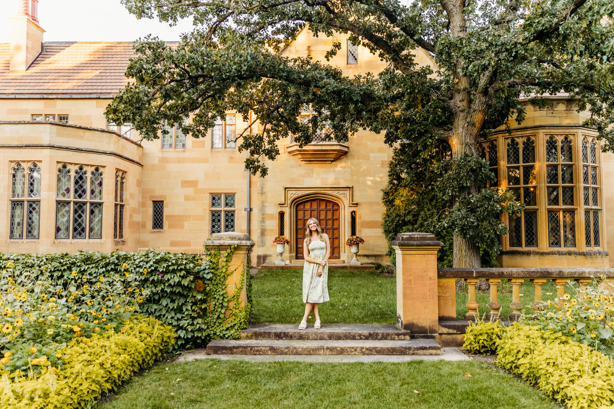 young woman in a dress standing in front of the mansion at Paine Art Center