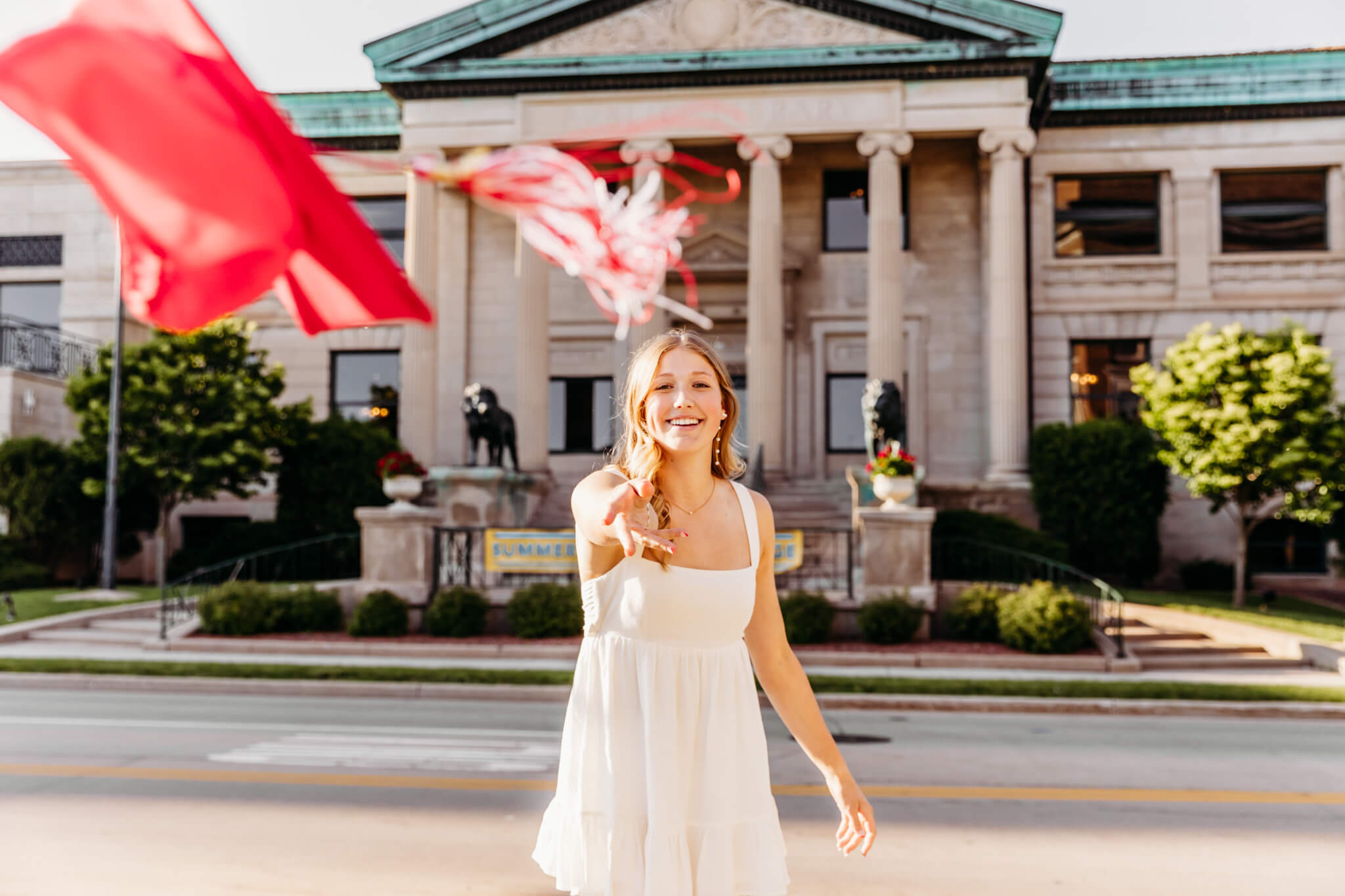 teenage girl throwing her graduation cap in front of her during her senior sesion