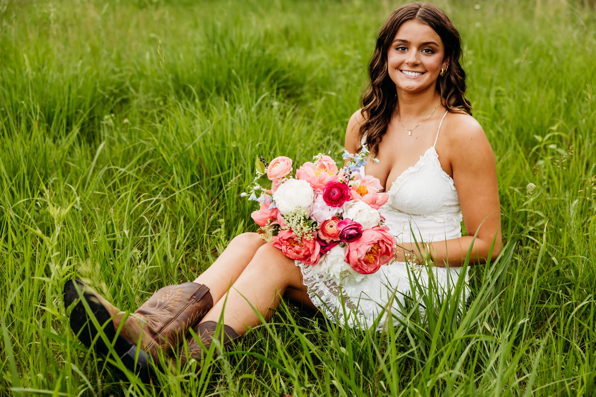 teenage girl in a white dress holding a flower bouquet and wearing cowboy boots
