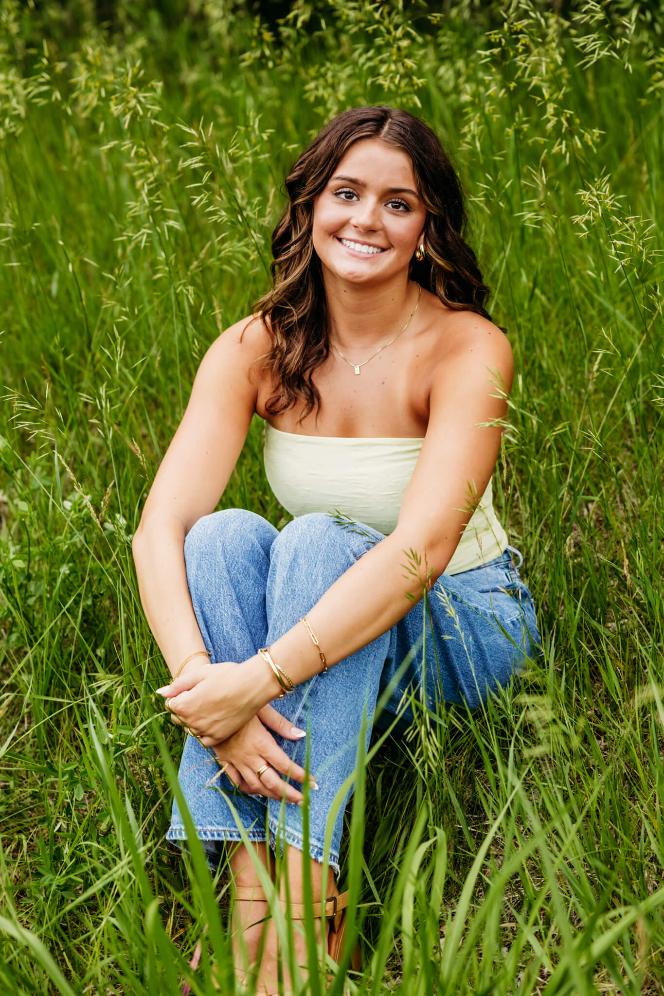 gorgeous teen girl with eyelash extensions sitting in a grassy field in Green Bay