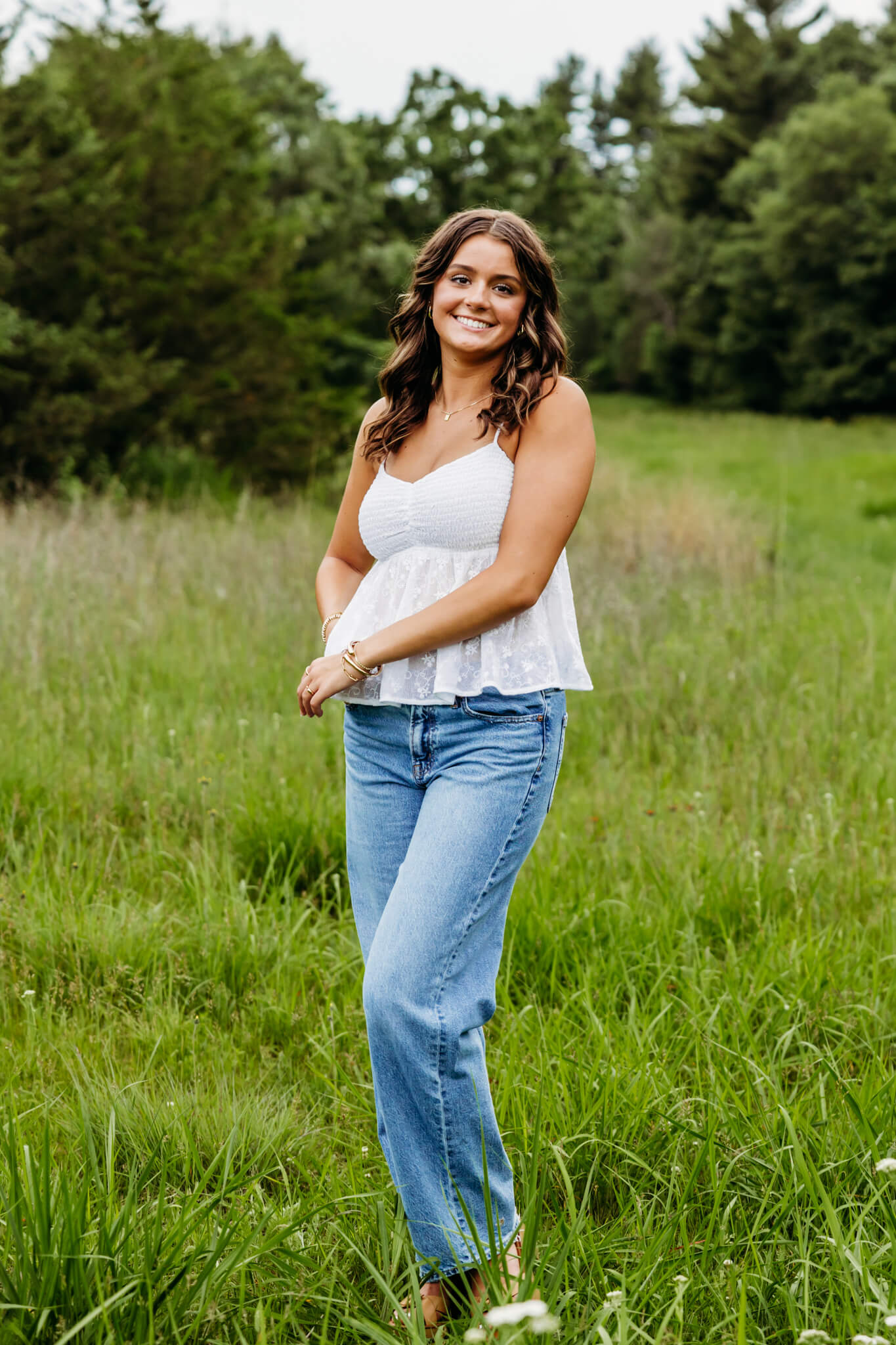 high school girl walking in a field and smiling