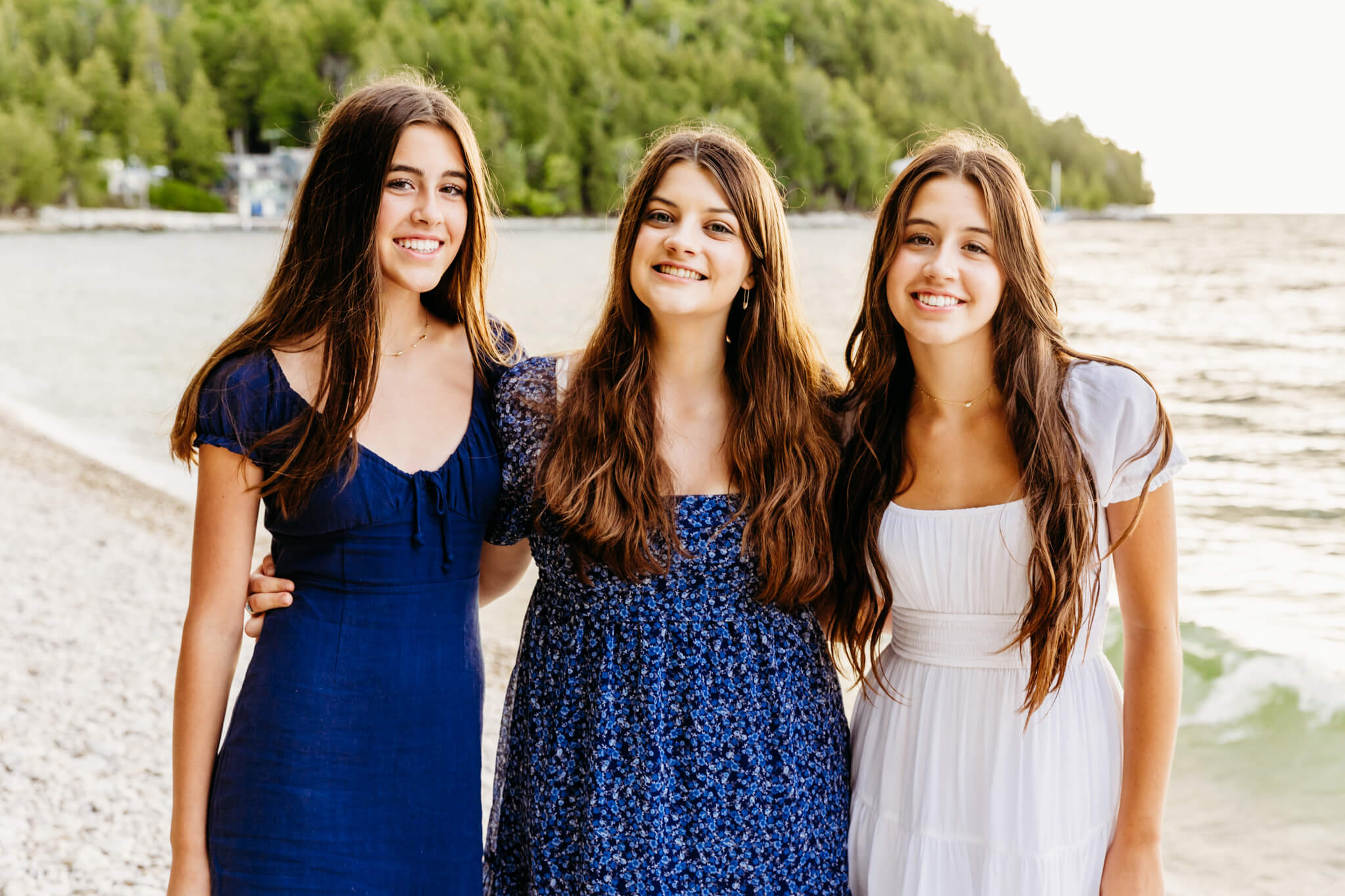 three sisters standing together on a beach in Door County for a blog post about Lautenbach's Orchard
