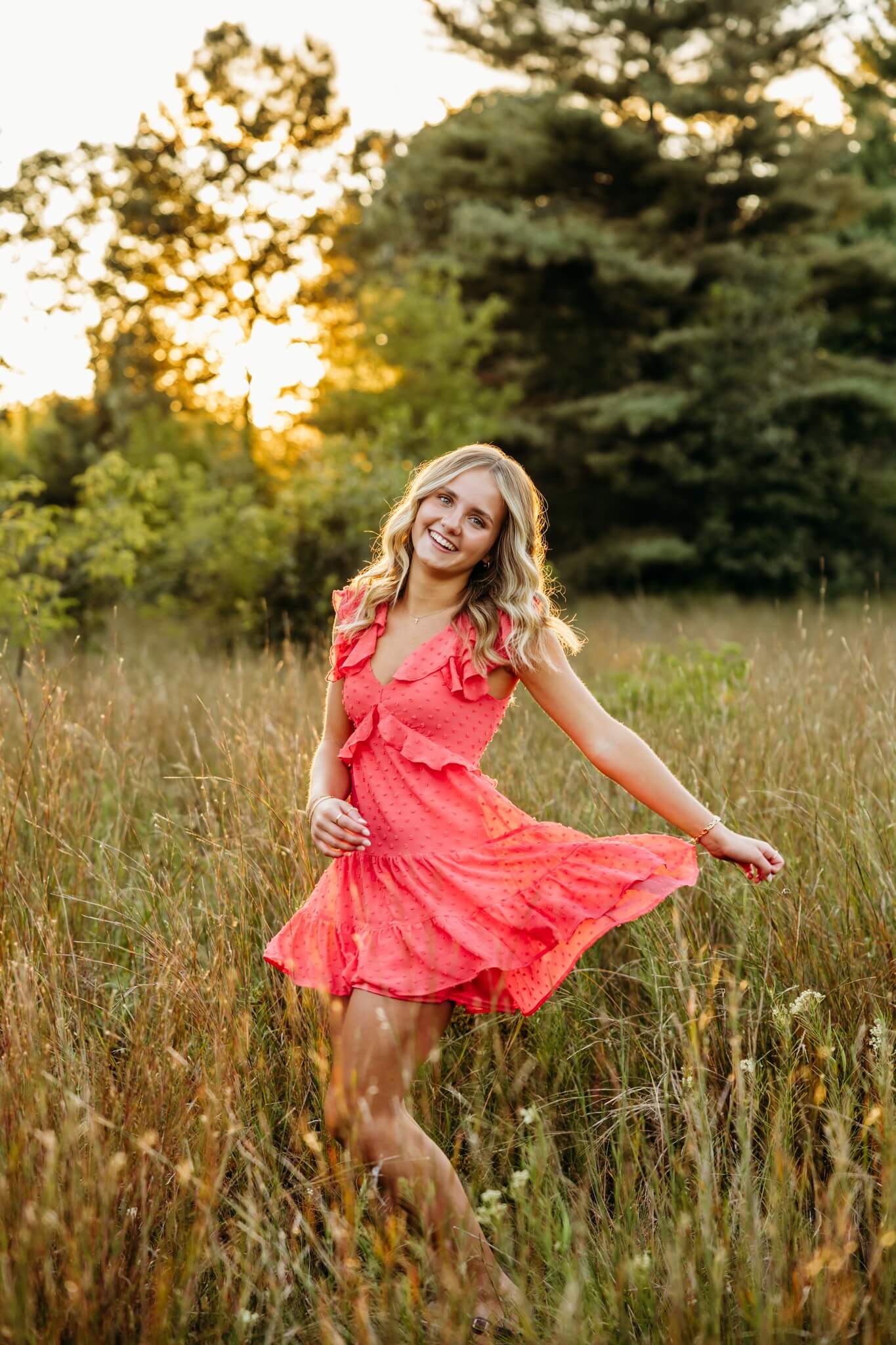 Gorgeous Appleton West High School senior playing with her pink dress while spinning in a field near Tellulah Park.